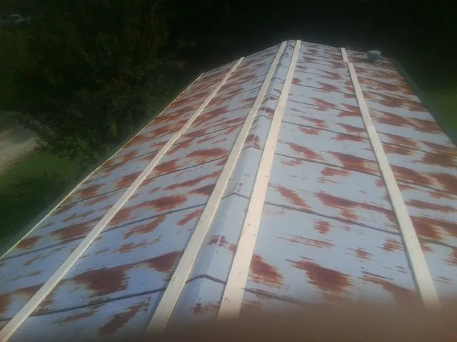 Rusted metal roof panels with new wood purlins before replacement — Storm Damage Roof Repair in Clovis by Roofing Brothers
